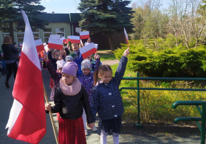 Dzieci wychodzące z przedszkola na pochód z flagami